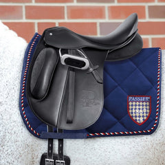 the passier evo-d dressage saddle on a white horse with a blue saddle pad